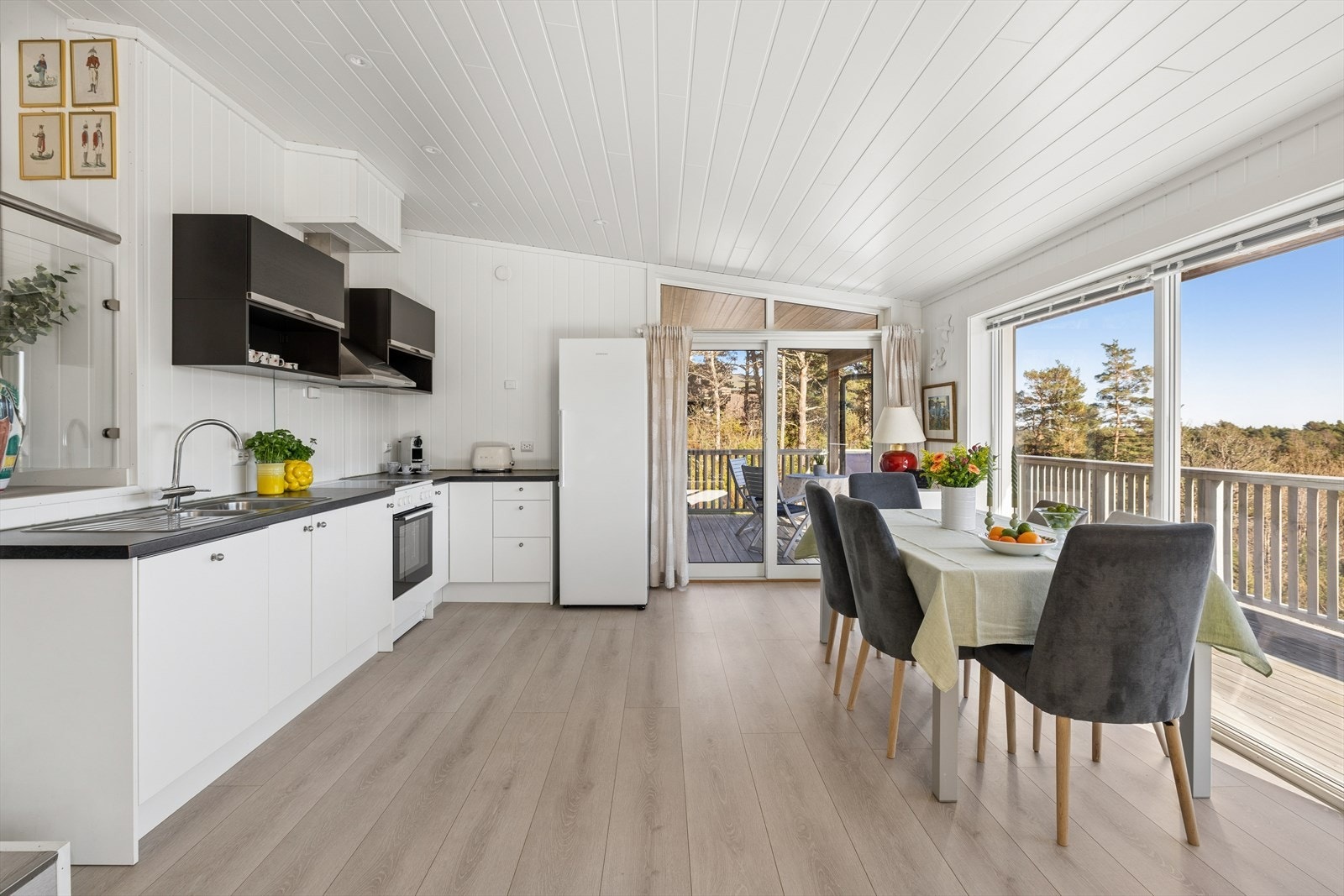 Kjøkken og spiseområde med store vinduer og utgang til terrasse Galleribilde
