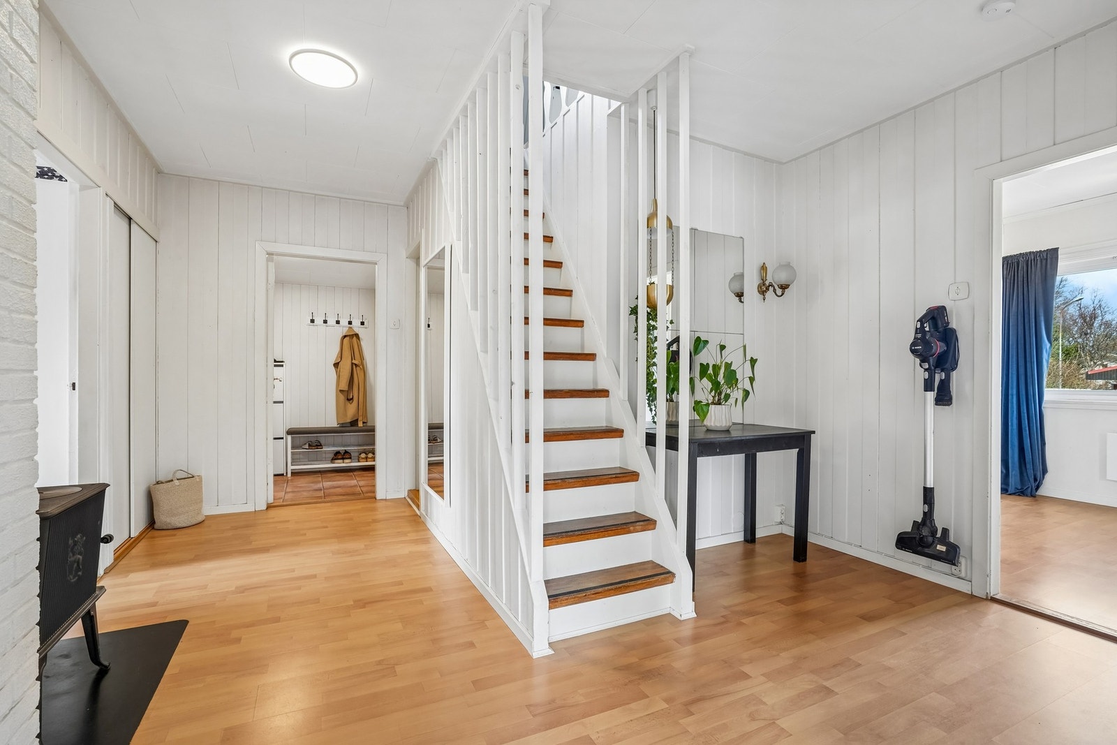 I gangen er det garderobeskap, trapp til loftet og det er montert vedovn. Galleribilde