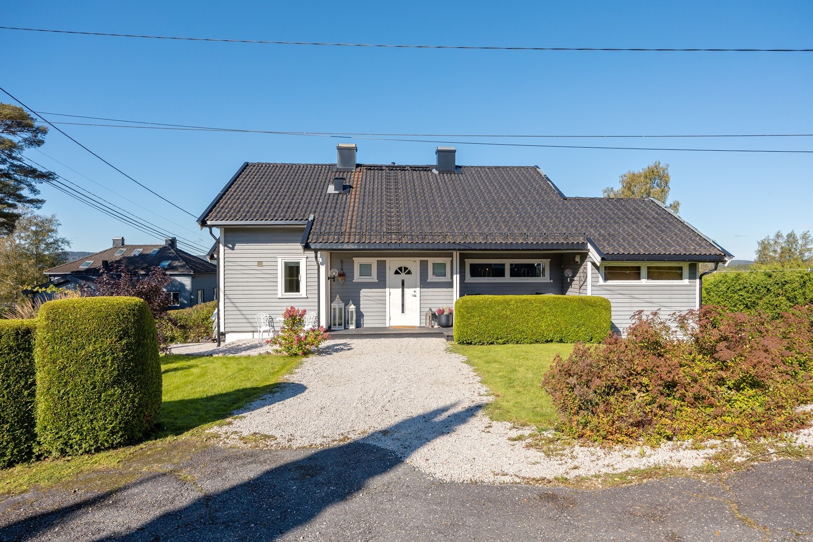 Eneboligen har et pent, overbygd inngangsparti med gruslagt adkomst, repos i tre og veggmontert utebelysning. Galleribilde