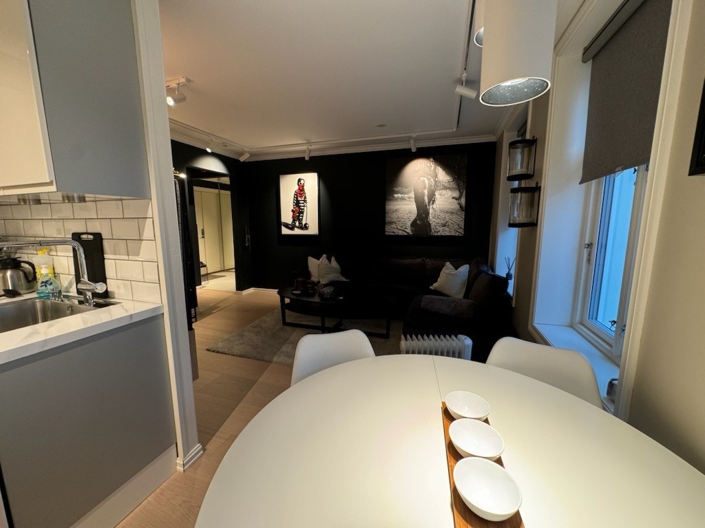Spisebord med stoler mellom kjøkken og stue. Galleribilde