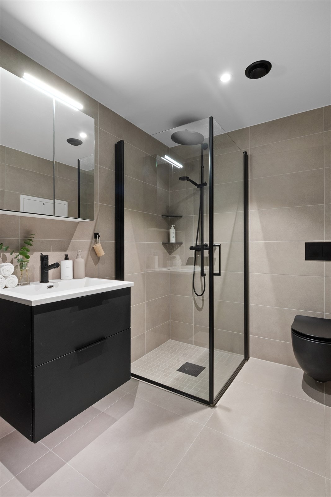 Badet har en praktisk dusjnisje med glassdører fra A-coll og takdusj, samt opplegg for vaskemaskin. Galleribilde