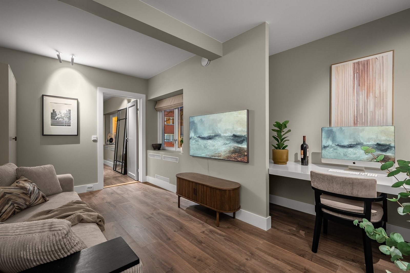 Stort plassbygget skrivebord med lagringsmuligheter i nisje bak TV-en. Galleribilde