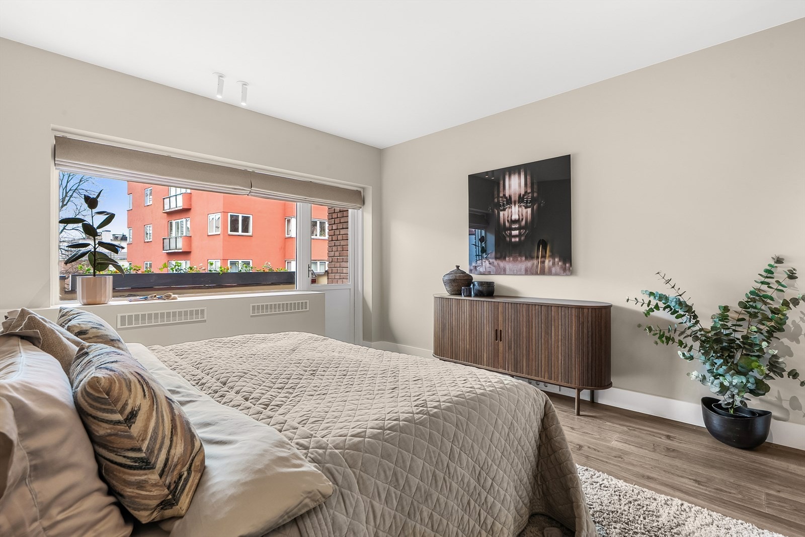 Store vindusflater med lystette liftgardiner og utgang til balkong. Galleribilde