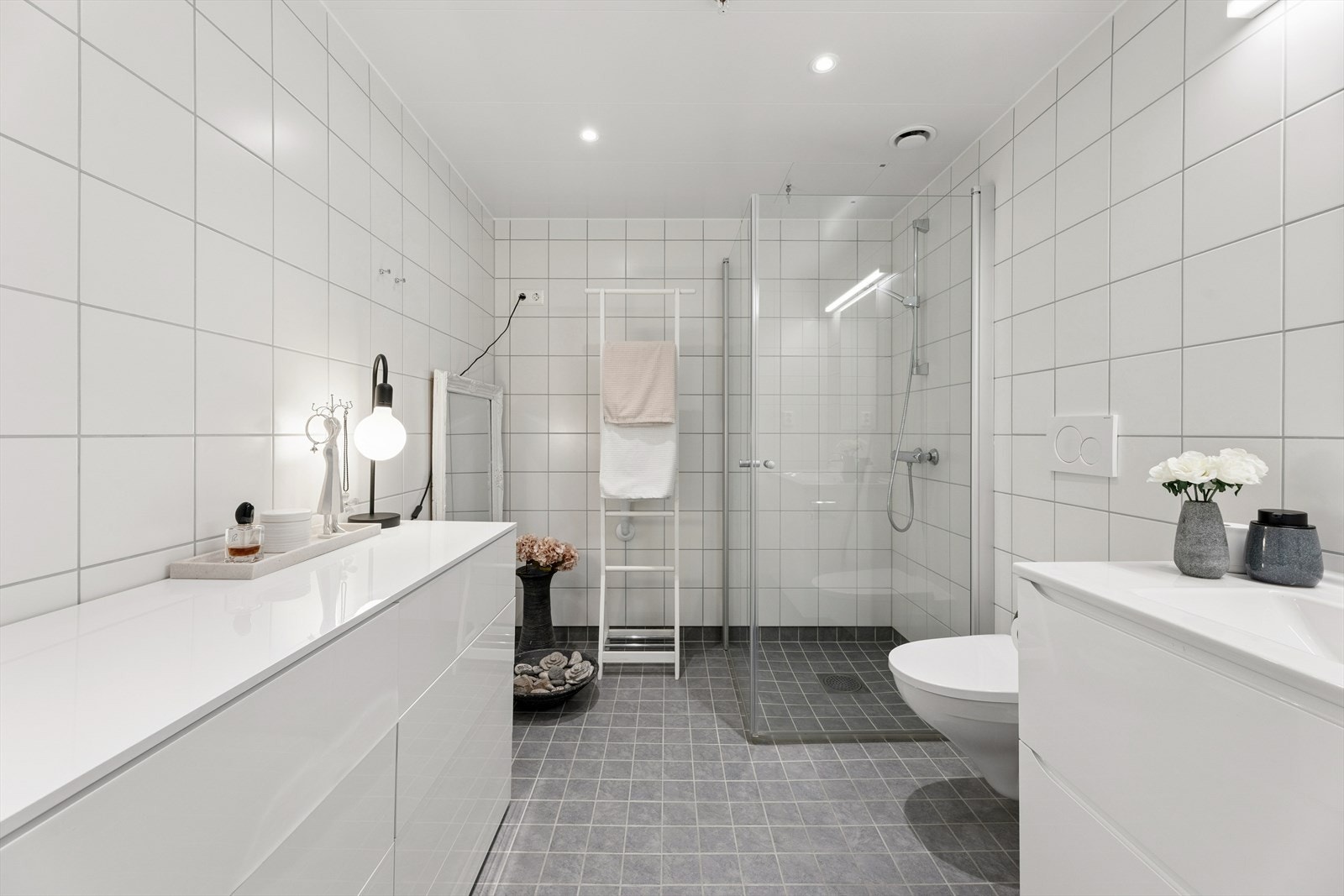 Leiligheten har to bad. Hovedbadet er romslig med flislagte overflater, vegghengt toalett og dusjhjørne. Galleribilde