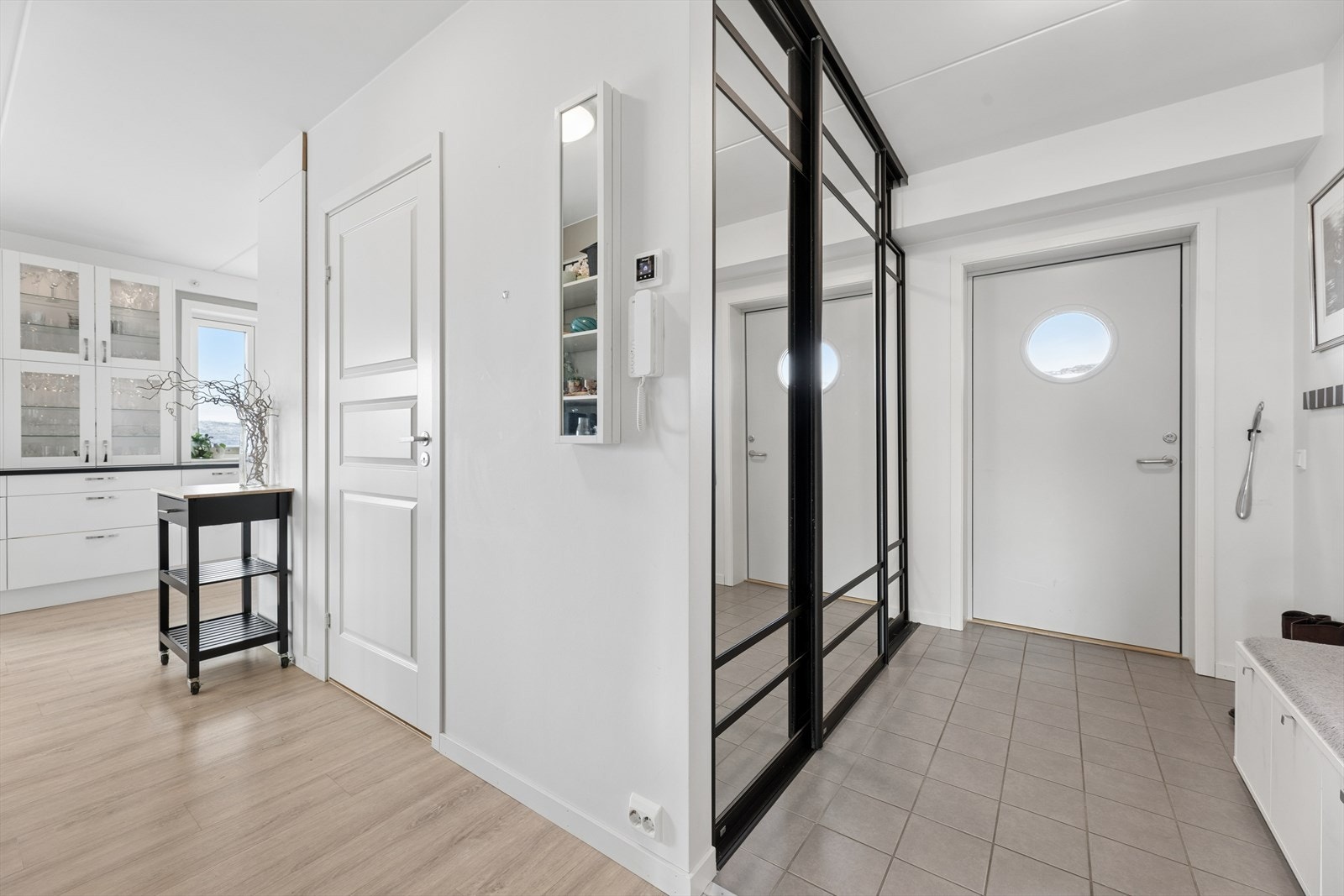 Entréen har flislagt gulv og en stor skyvedørsgarderobe med speilfronter som gir rikelig med oppbevaringsplass. Galleribilde