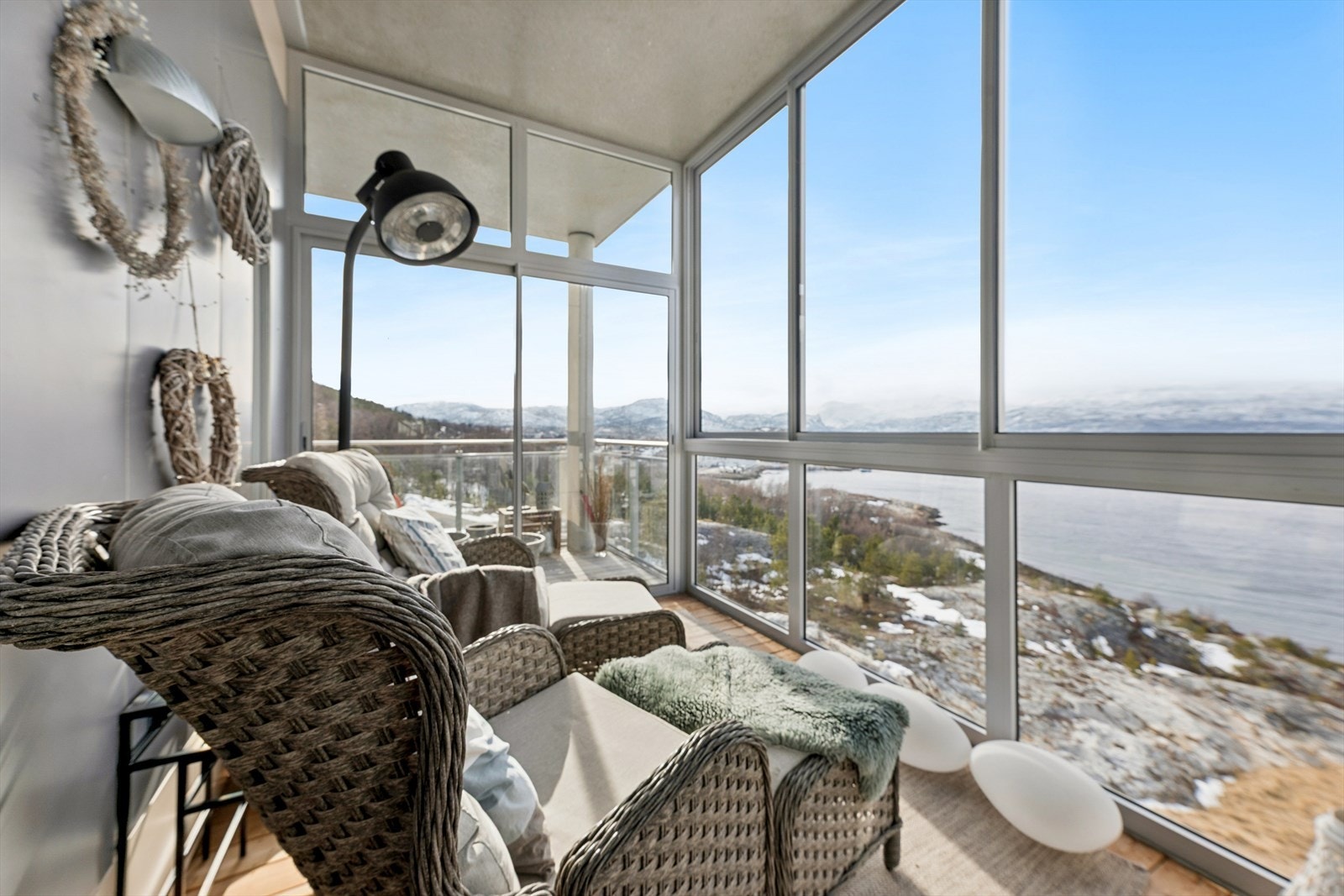Den innglassede verandaen fungerer som en forlengelse av stuen, og gir et lunt uterom med panoramautsikt. Galleribilde