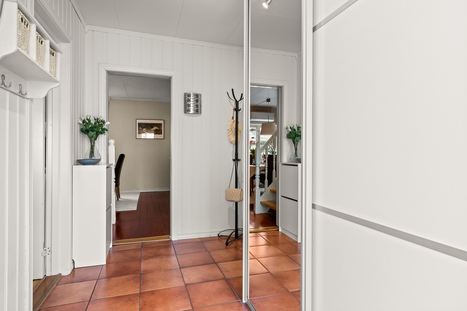 Entré med flislagt gulv og skyvedørsgarderobe. Herfra er det adkomst til kjøkken, stue og trapperom. Galleribilde
