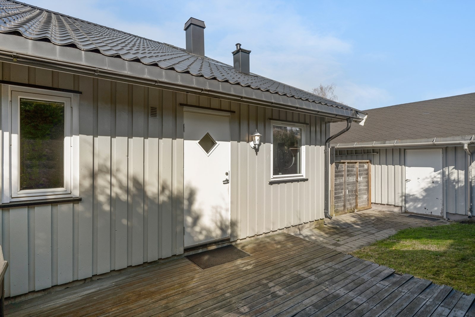 Hagen på baksiden er pent opparbeidet med en romslig terrasse i tre, som gir et hyggelig og skjermet uteområde rett utenfor boligen. Galleribilde