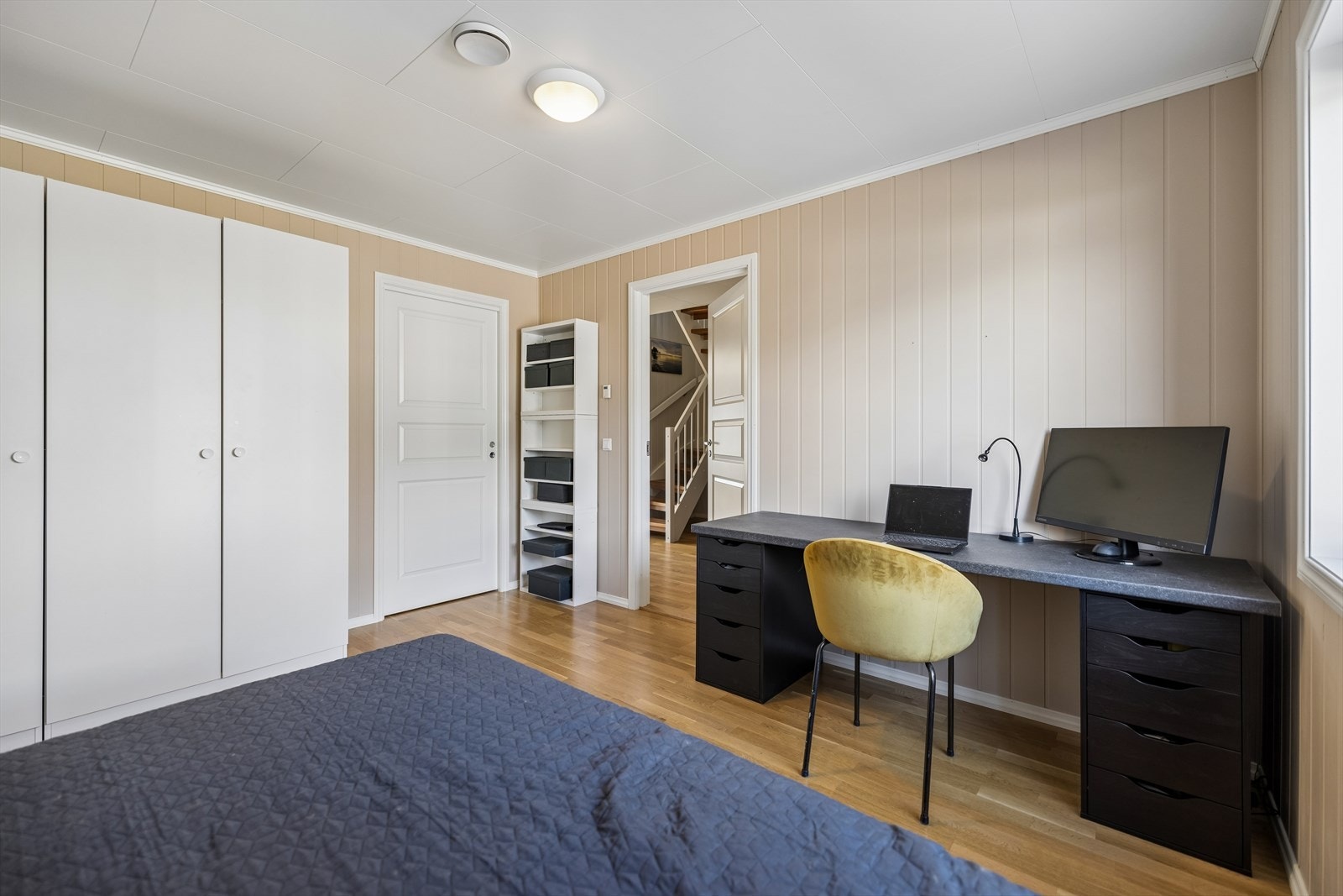 Rommet har god plass til både seng og arbeidsplass. Veggene har malte panelplater. Galleribilde