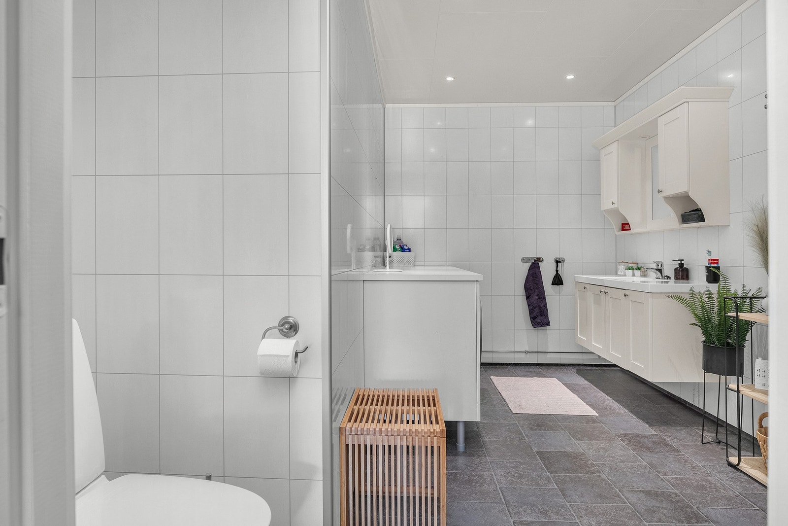 Stort og fint bad fra 2021 med baderomsplater på veggene og våtromsbelegg på gulv Galleribilde