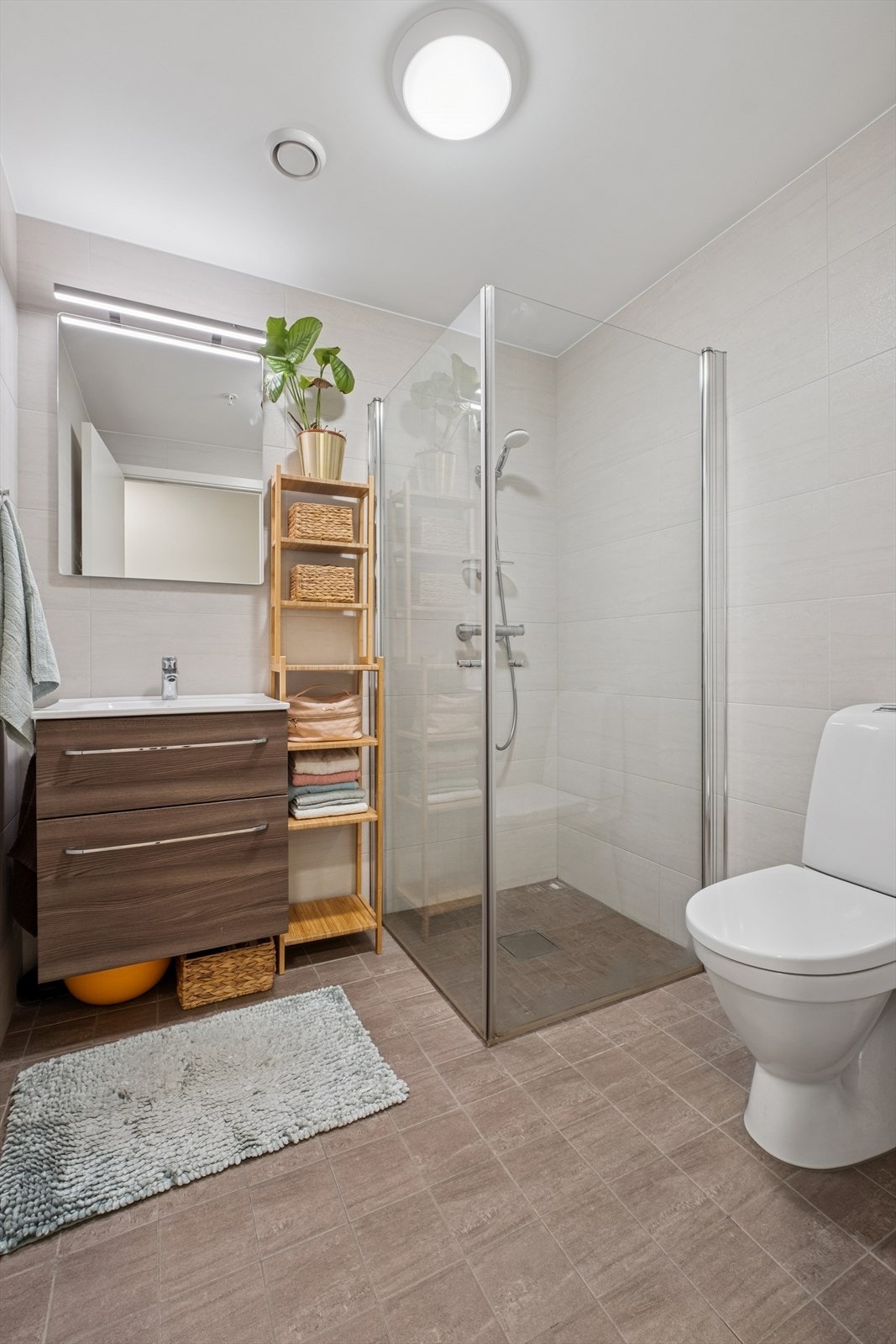 Lekkert bad/wc med varme i gulv, servantskap, speil og svingbare dusjdører. Galleribilde