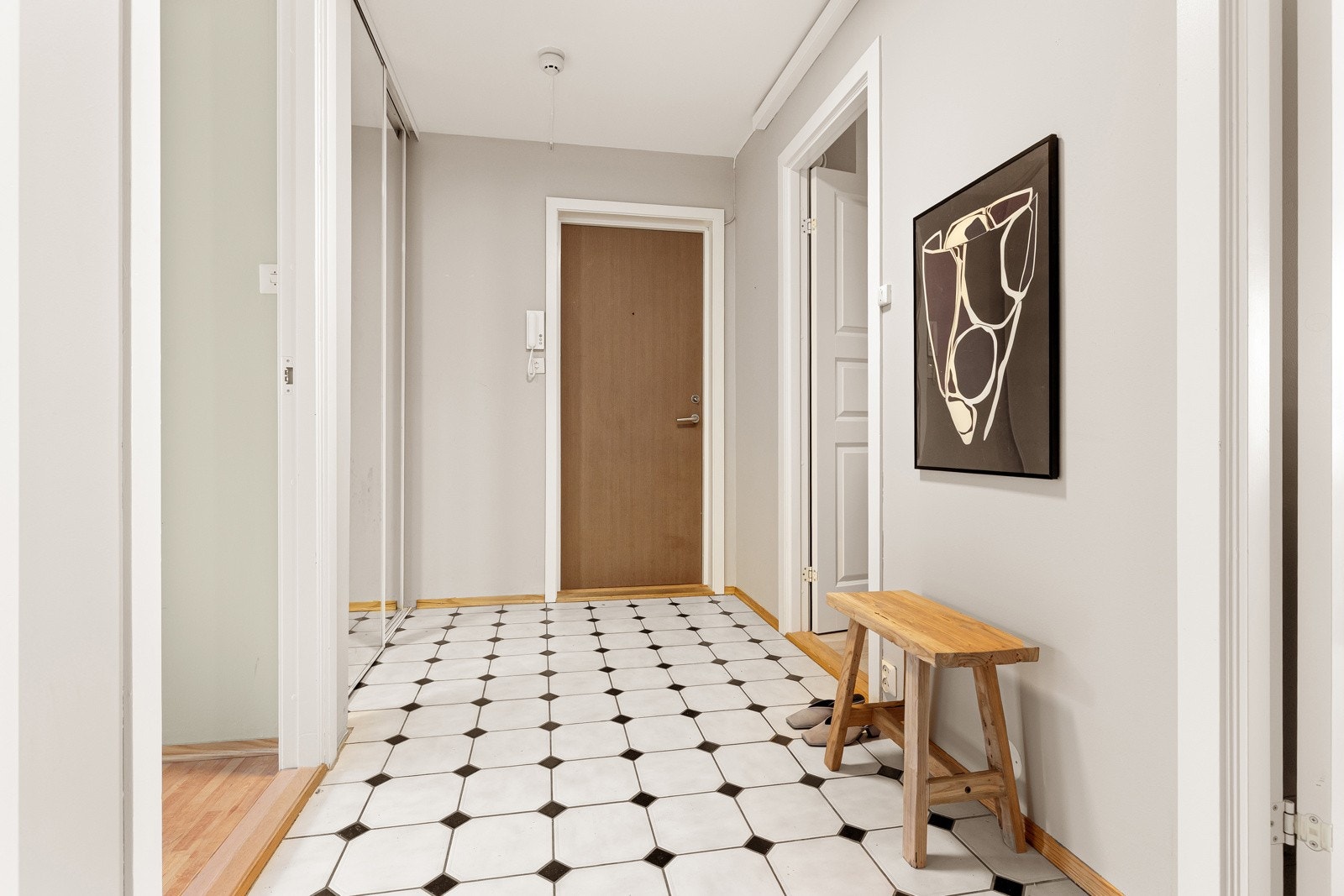 Romslig entré innredet med skyvedørsgarderobe med speilfronter. Galleribilde