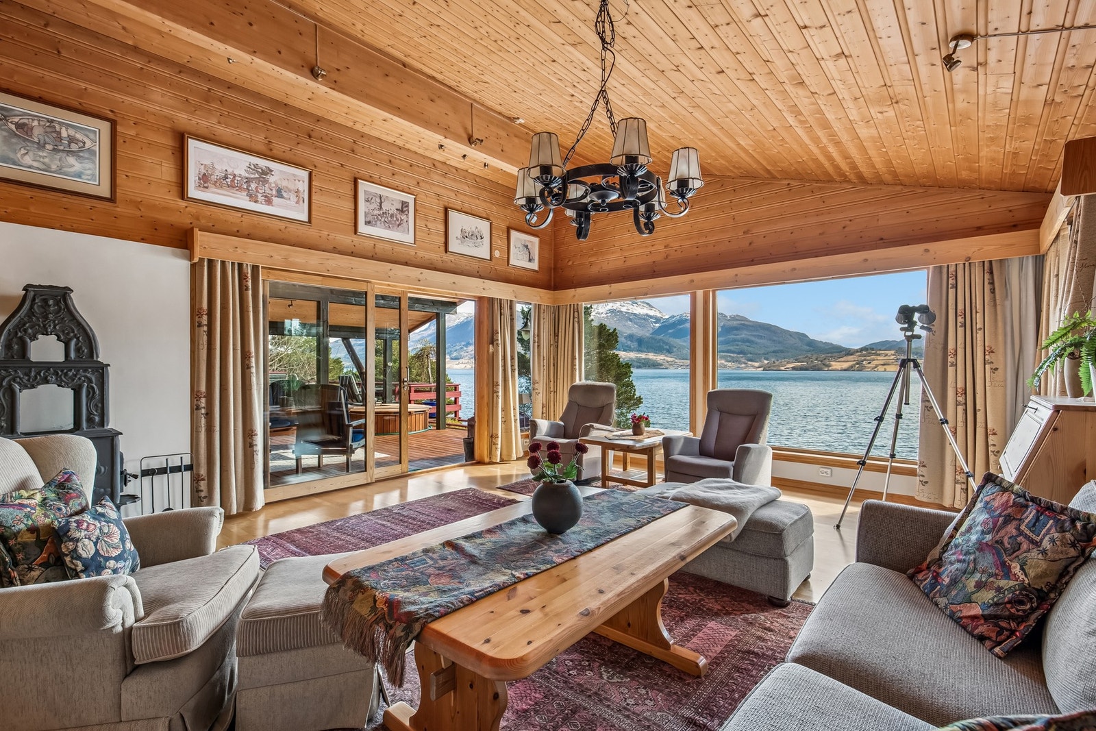 Stue med store vinduer og flott utsikt. Her er det utgang til overbygd terrasse Galleribilde