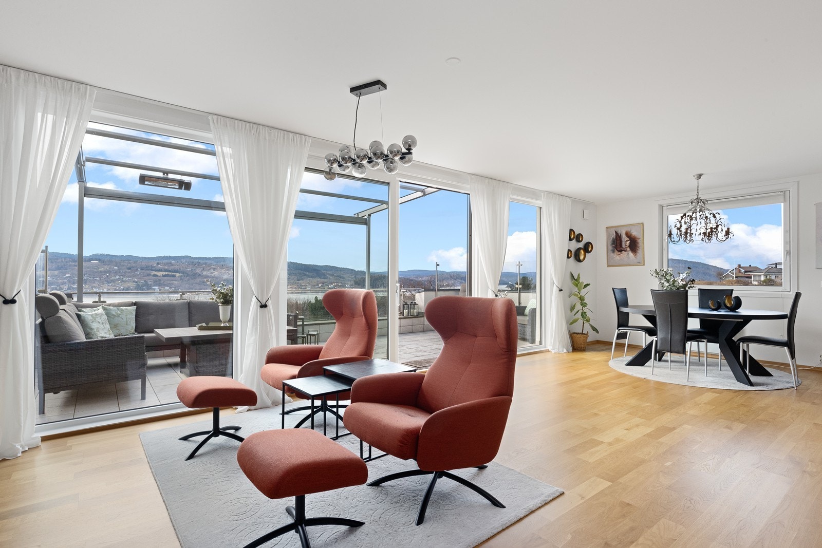 Store heve-/skyvedører i tre og isolerglass visker ut skillet mellom inne og ute. Galleribilde