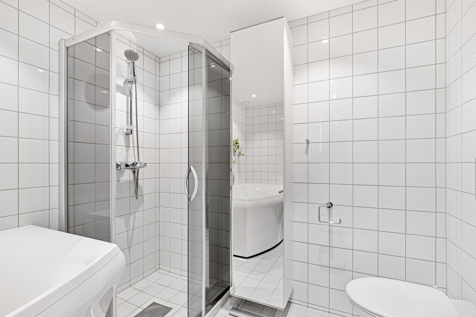 Badet er utstyrt med både dusjhjørne og badekar, samt gulvvarme og downlights. Galleribilde