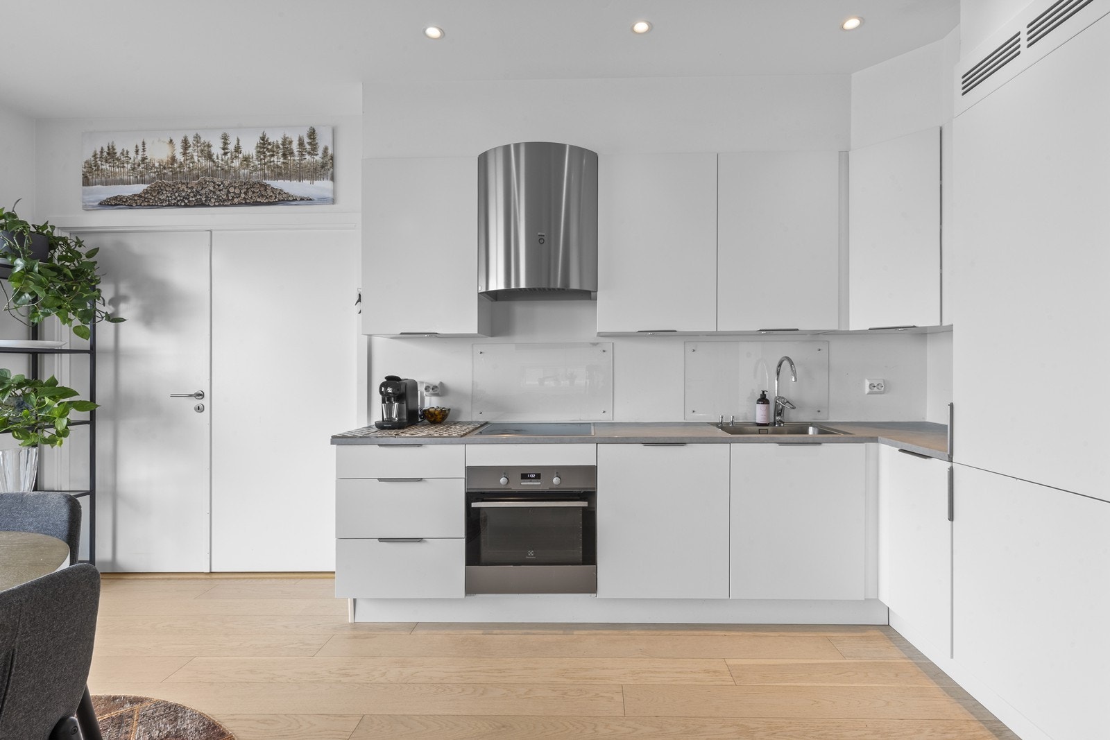 Glassfelt bak vasken og platetoppen gjør det enkelt å holde kjøkkenet rent, samtidig som det gir en elegant og moderne finish. Galleribilde