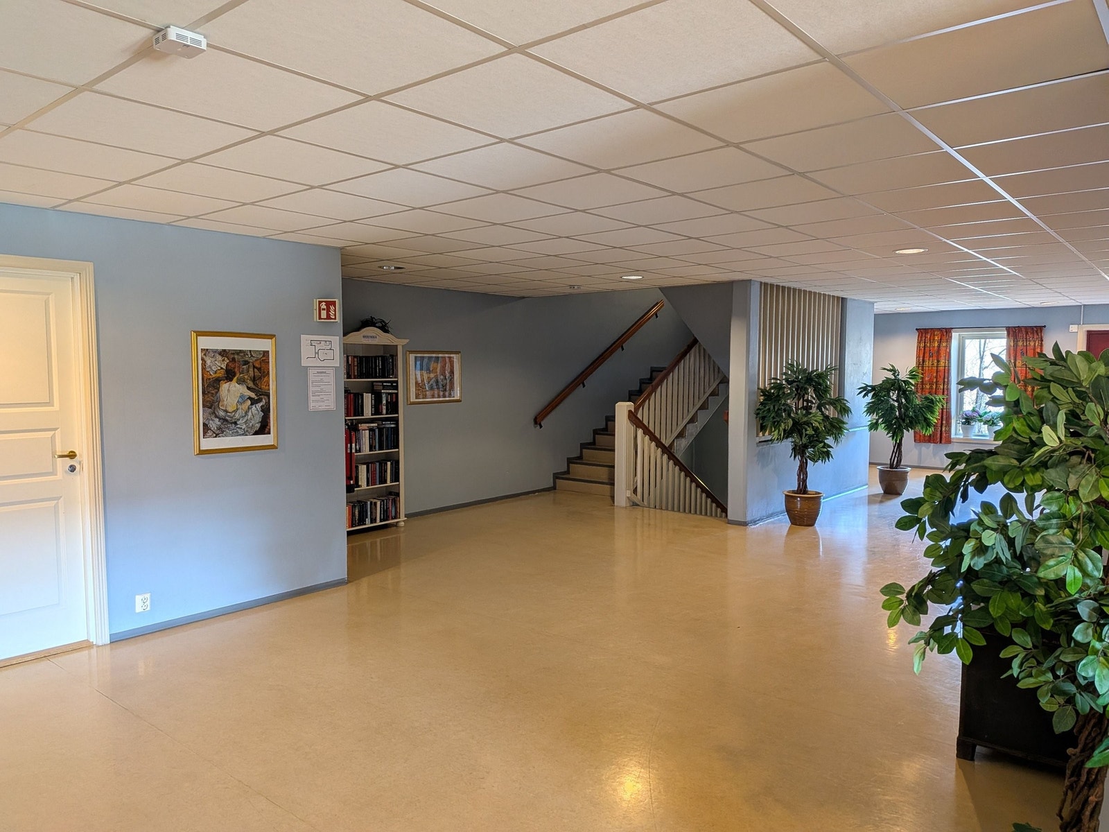 Foajé hovedinngang med bokhylle leste bøker til utlån. Galleribilde