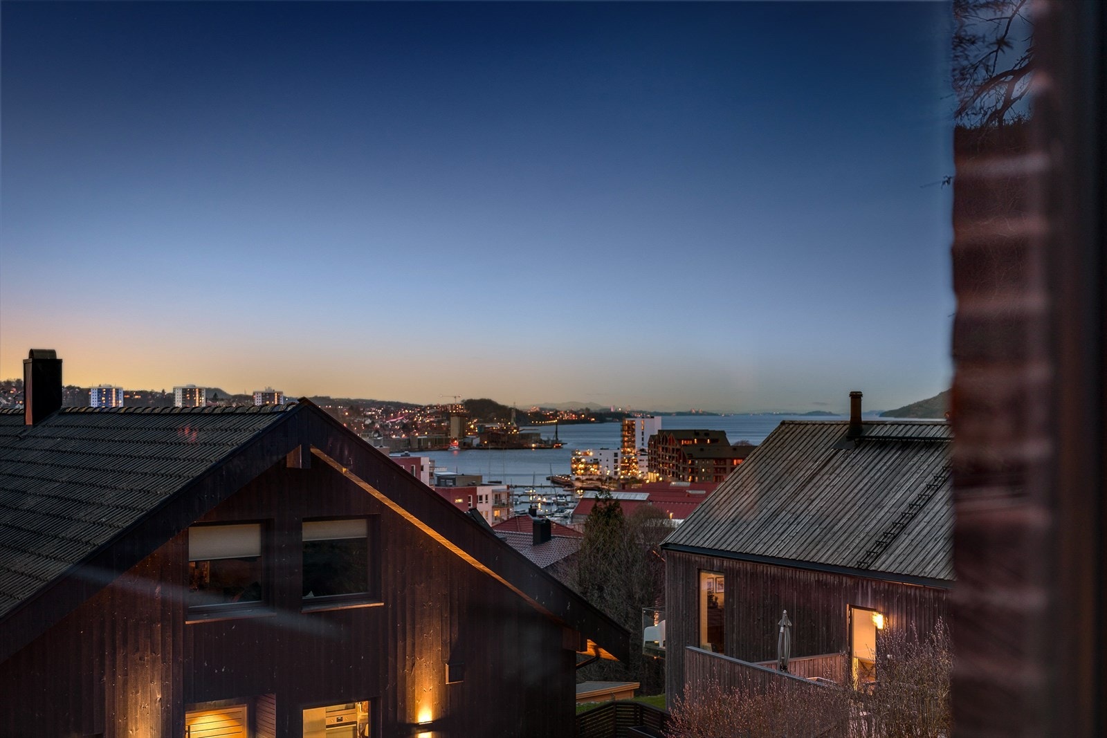 Herlig utsikt over by og fjord i kveldslys. Galleribilde
