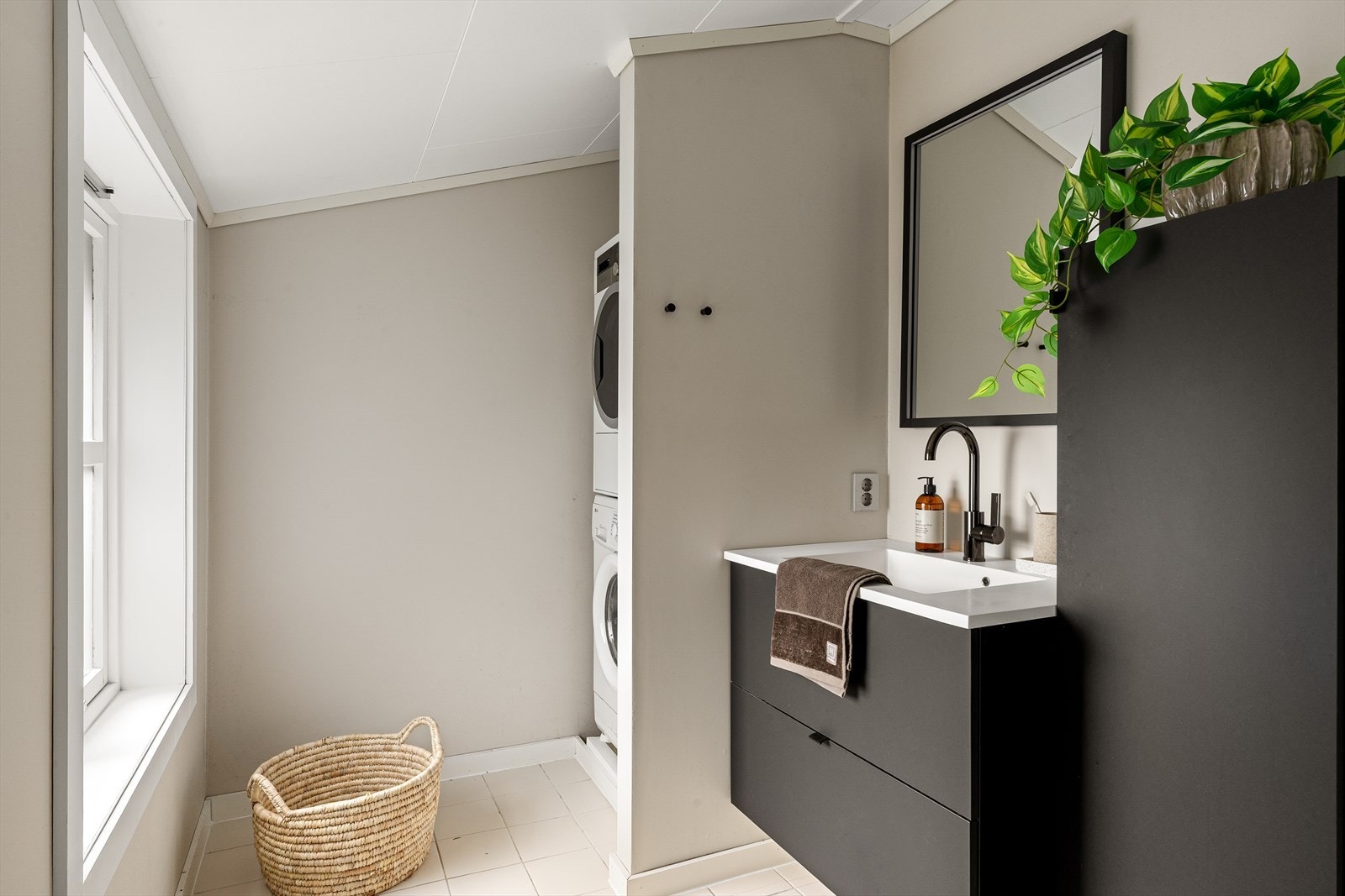 Bad med moderne servantinnredning og opplegg for vaskemaskin. Galleribilde