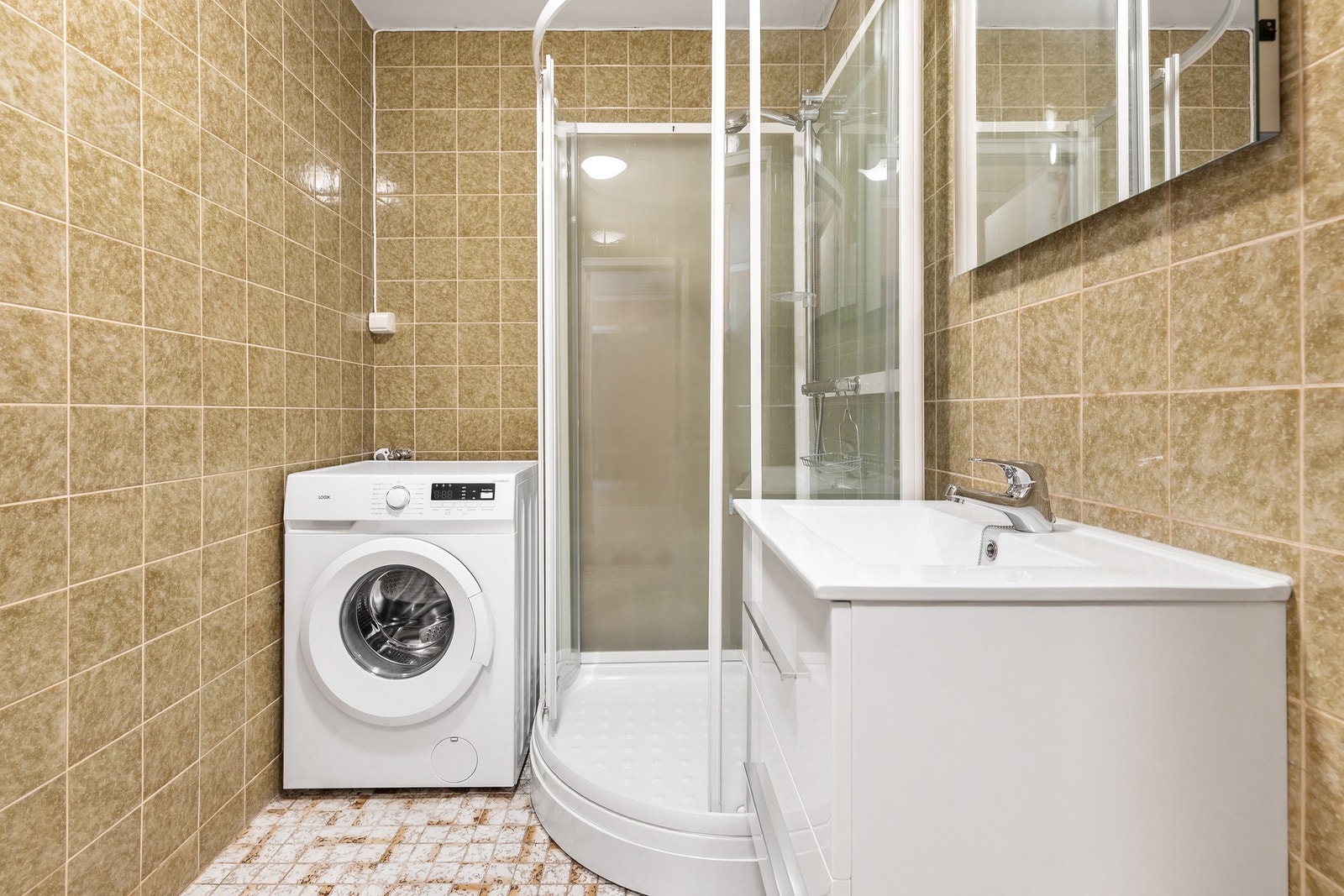 Rommet er innredet med dusjkabinett, servantinnredning og opplegg til vaskemaskin Galleribilde
