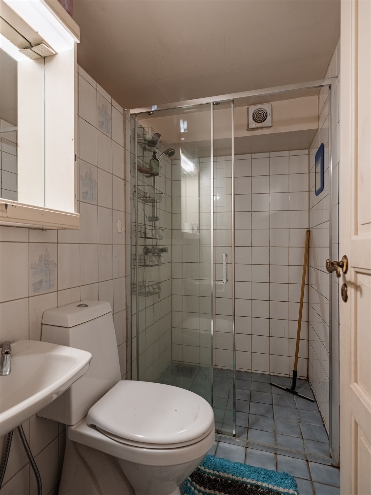 Badet i underetasjen er av eldre dato, med fliser på gulv og vegger, dusj, klosett og servant. Galleribilde