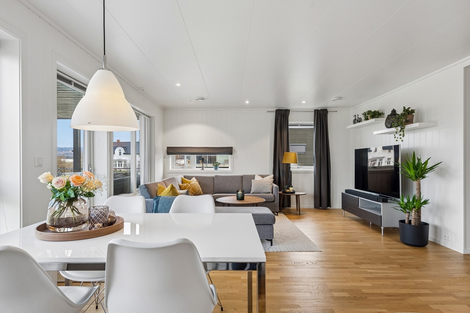 Store vindusflater med isolerglass og utgang til balkongen gir rikelig med dagslys til den sosiale sonen. Galleribilde