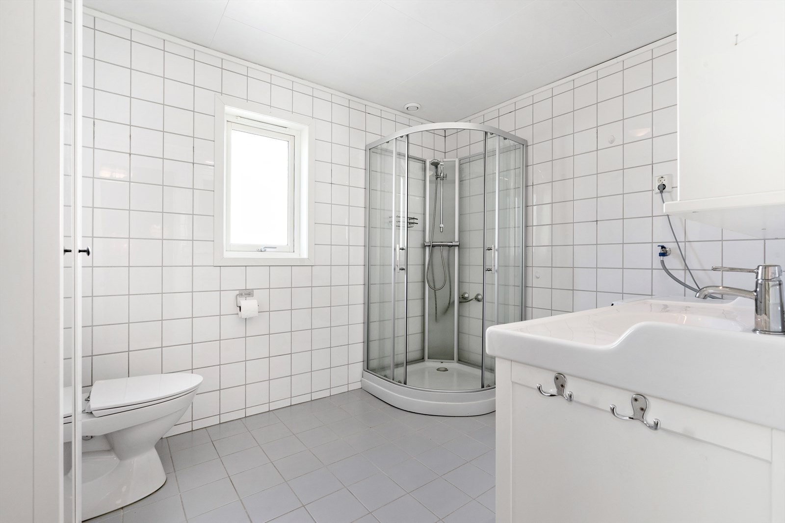 Flislagt bad med varmekabler i gulv og opplegg for vaskemaskin Galleribilde