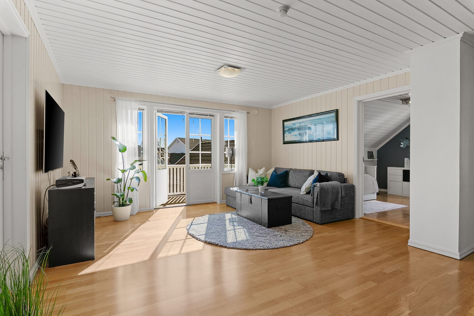 Romslig lofstuestue med utgang til balkong og plass til sofagruppe. Galleribilde