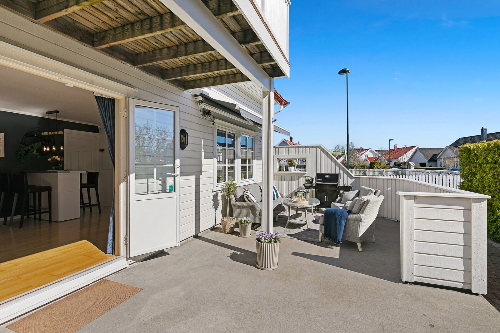 Uteplass med sittegruppe og grill, skjermet med gjerde og direkte adkomst fra stue. Galleribilde