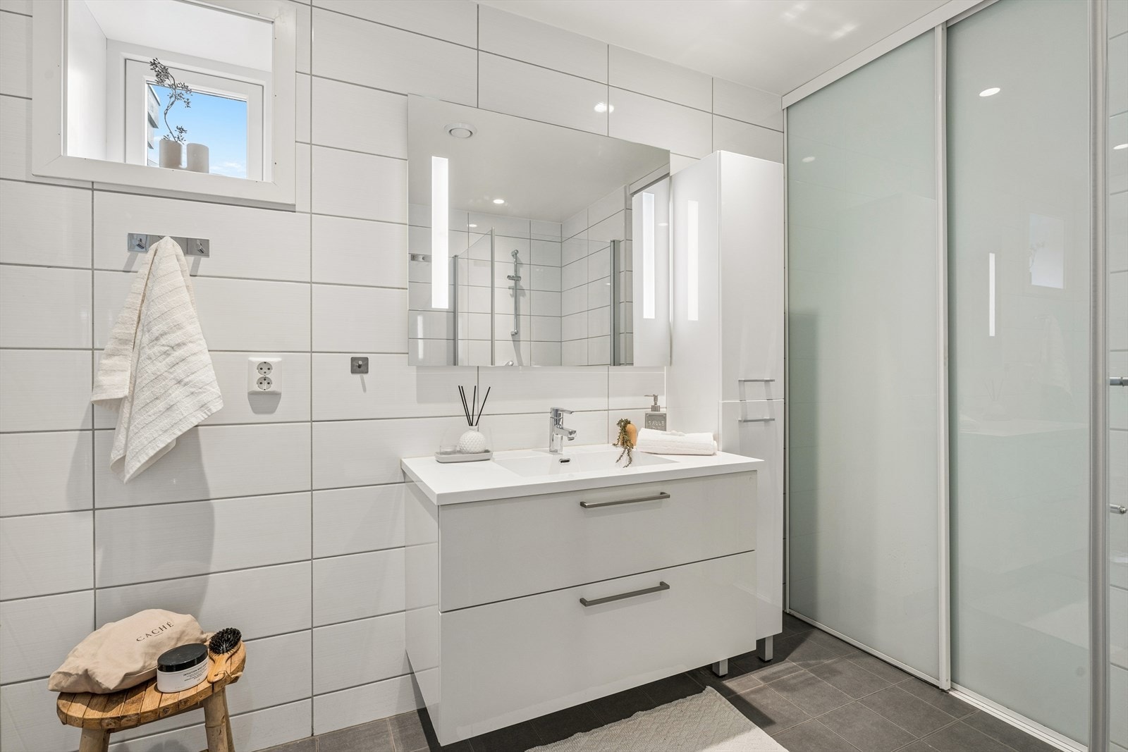 Baderomsinnredning med nedfelt servant og speilskap med belysning. Downlights i taket. Galleribilde
