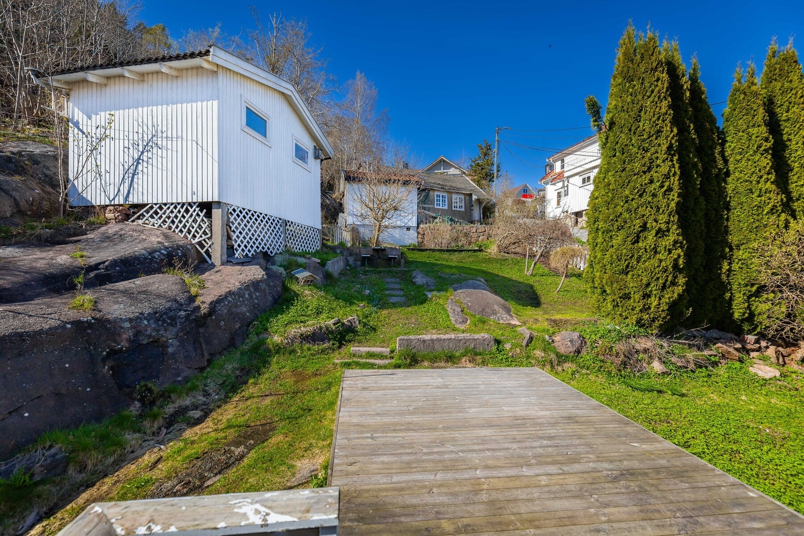 Koselig og pen hage med sjøbod og sittegruppe. Galleribilde