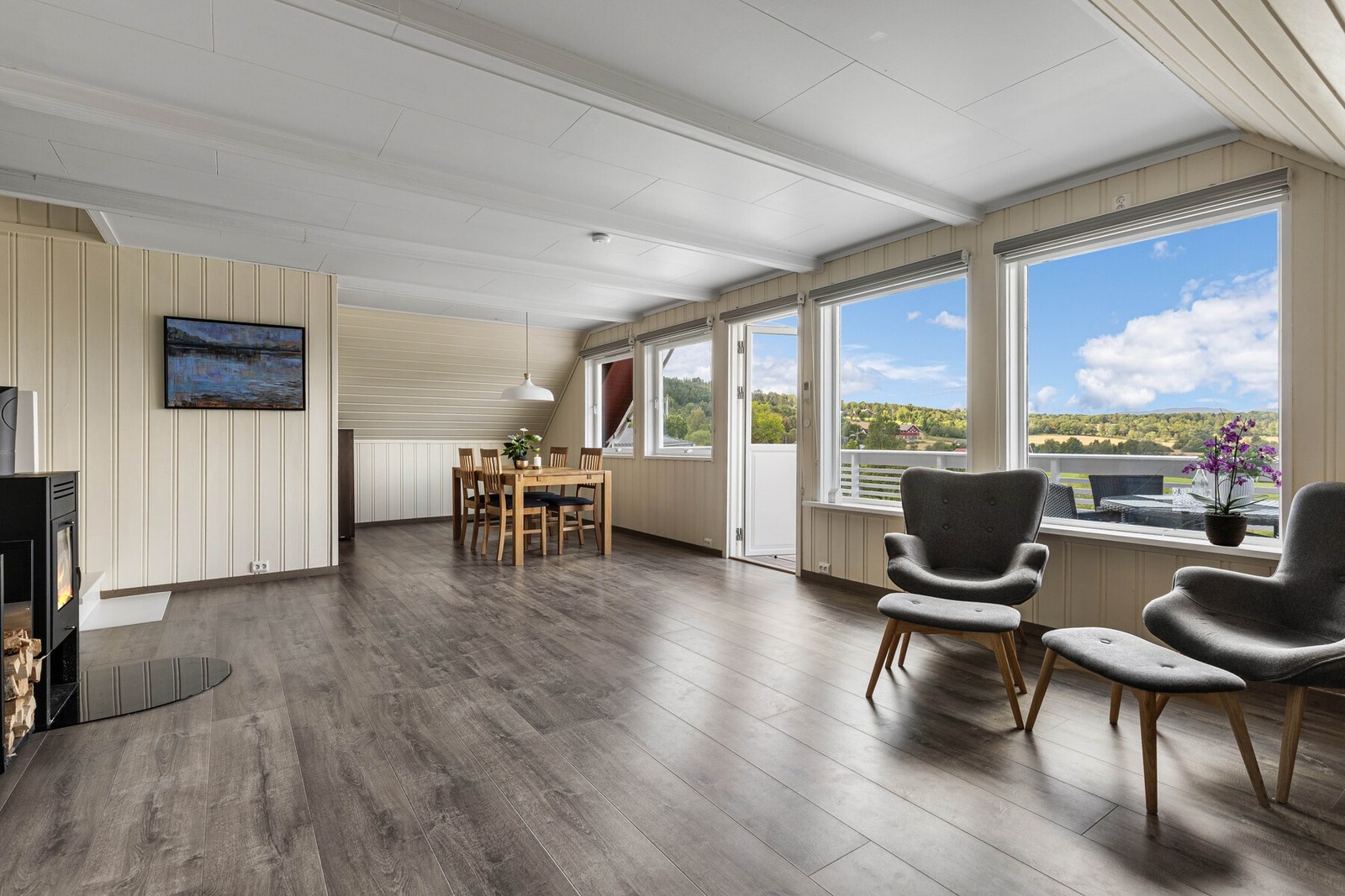 Fra entreen leder en trapp opp til boligens hovedoppholdsrom - en lun og romslig stue i åpen løsning med spisestue. Galleribilde