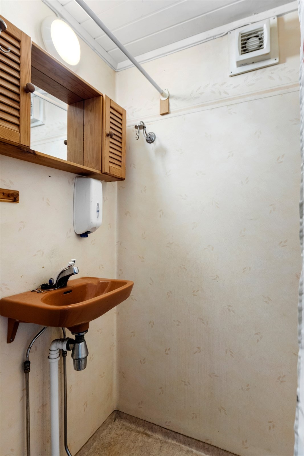 Badet holder enkel standard med våtromsbelegg. Dusj med forheng og servant med speilskap. Galleribilde