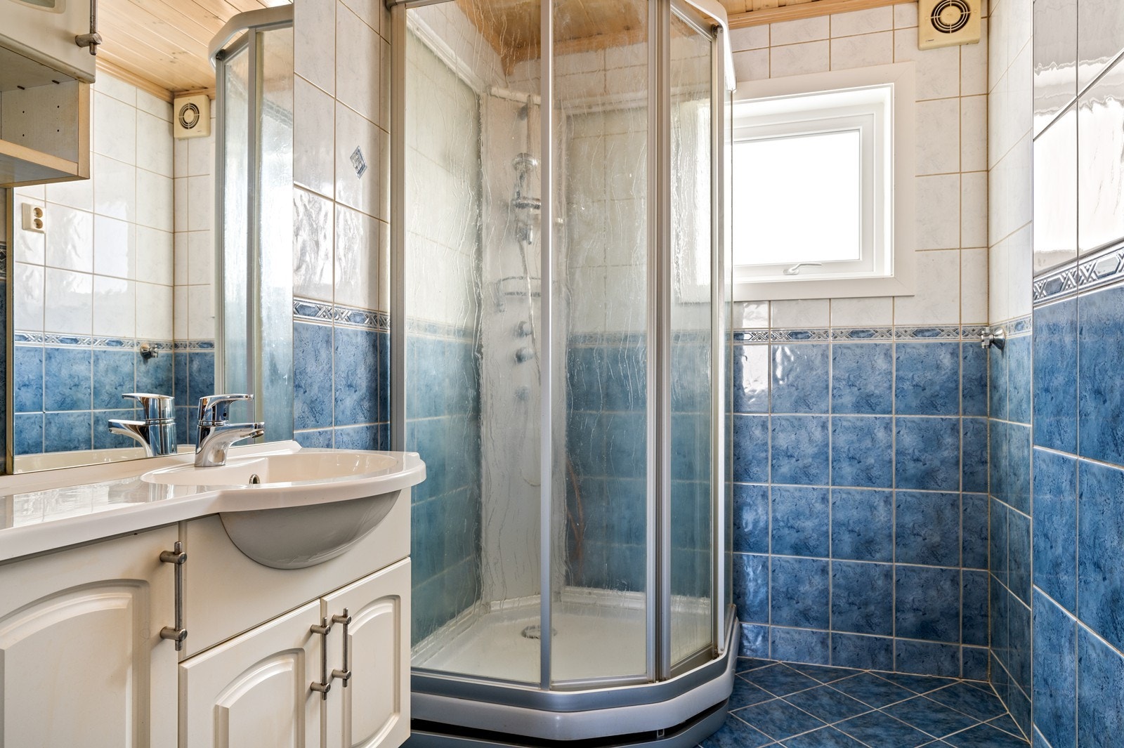 Badet ha en standard fra 1990- årene og har flislagte overflater på gulv og vegger, og er utstyrt med dusjkabinett. Videre er det servantskap med lagring, og speil over vasken med ett overskap. Det er vegghengt wc. Galleribilde