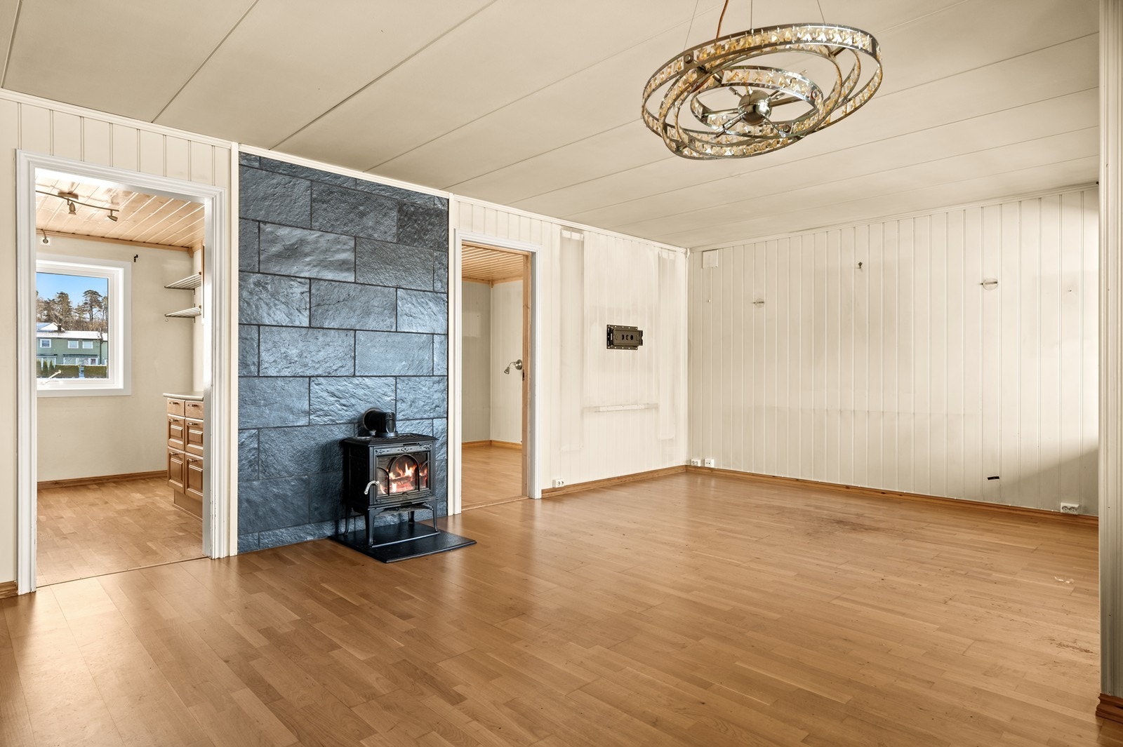 En vedovn montert mot mursteinspipe belagt med fliser, gir en lun og god varme i stuen. Galleribilde