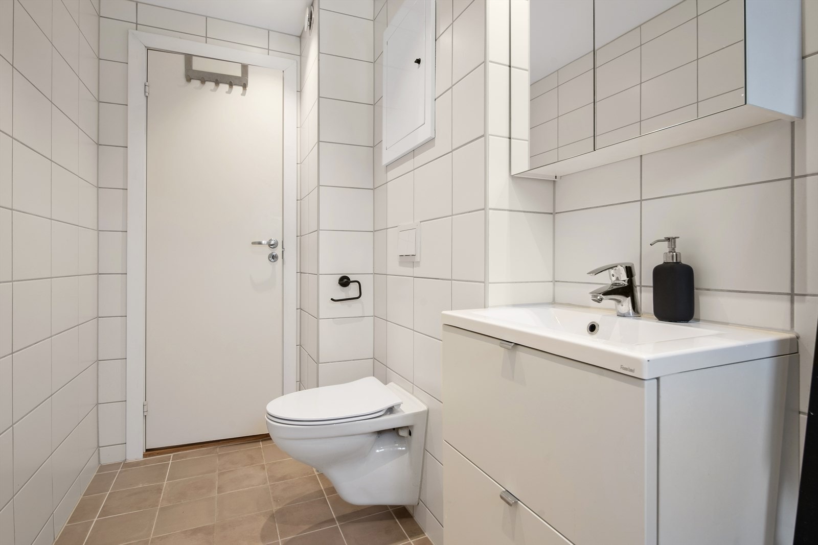 Badet fremstår lyst og innbydende, med flislagte vegger og gulv som gir et stilrent og lettstelt uttrykk. Elektriske varmekabler i gulvet sørger for behagelig komfort. Galleribilde