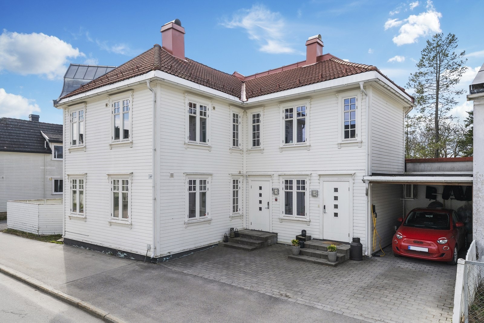 Steinlagt gårdsplass, og det medfølger carport med elbil-lader. Galleribilde