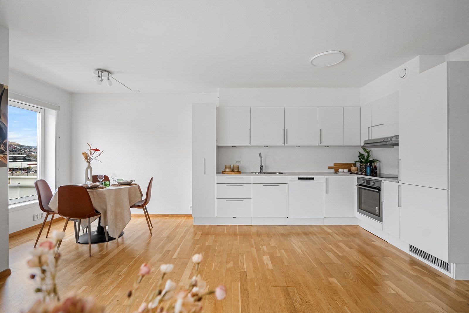 L-formet kjøkken med innredning i glatte fronter som gir et moderne og stilrent uttrykk. Galleribilde
