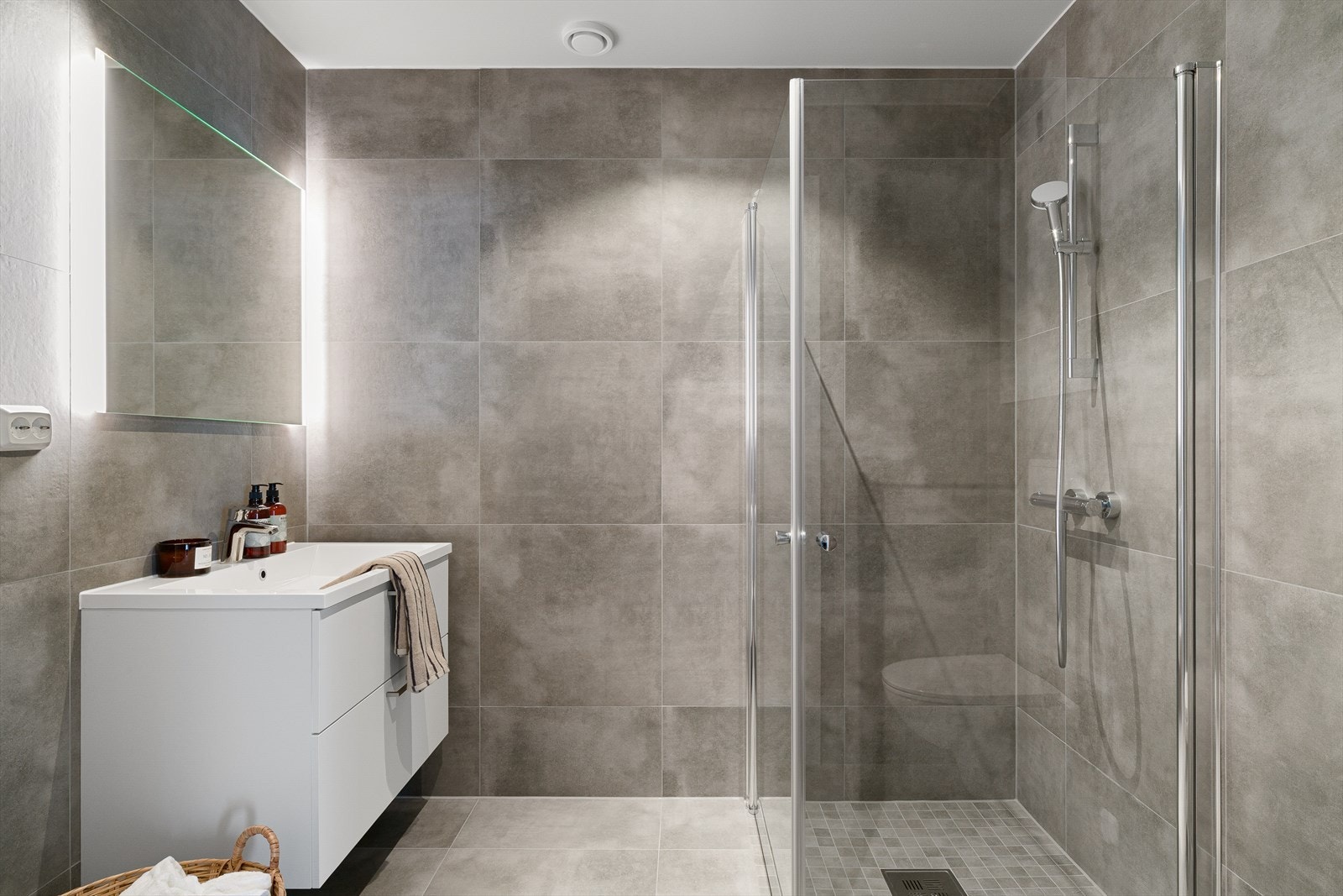 Badet er helfliset med store, moderne 60x60 fliser i grå utførelse og fremstår både stilrent og tidløst. Galleribilde