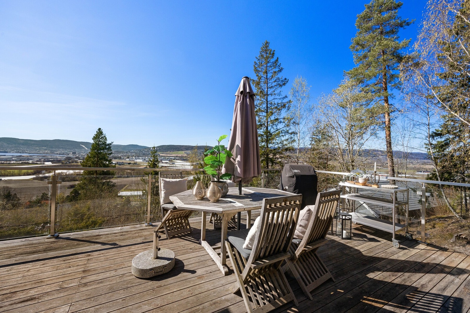 Stor terrasse med glassrekkverk og flott utsikt over Lierdalen Galleribilde
