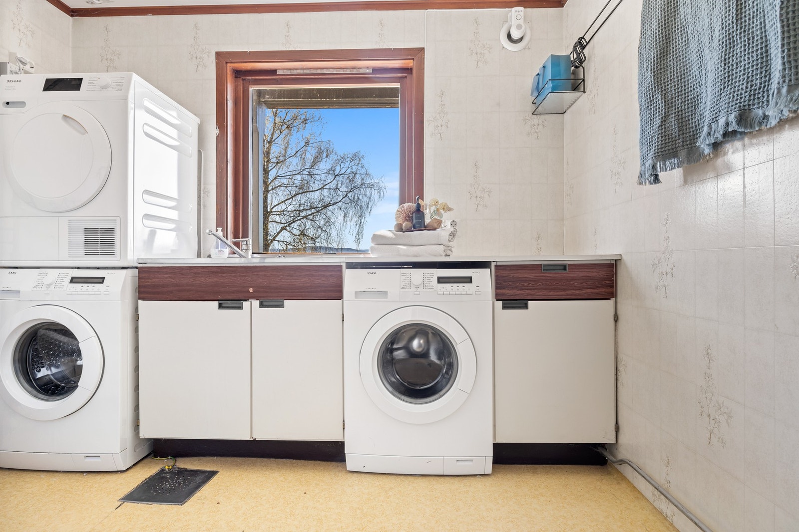 Vaskerom med vaskemaskin, tørketrommel, vask og skap Galleribilde