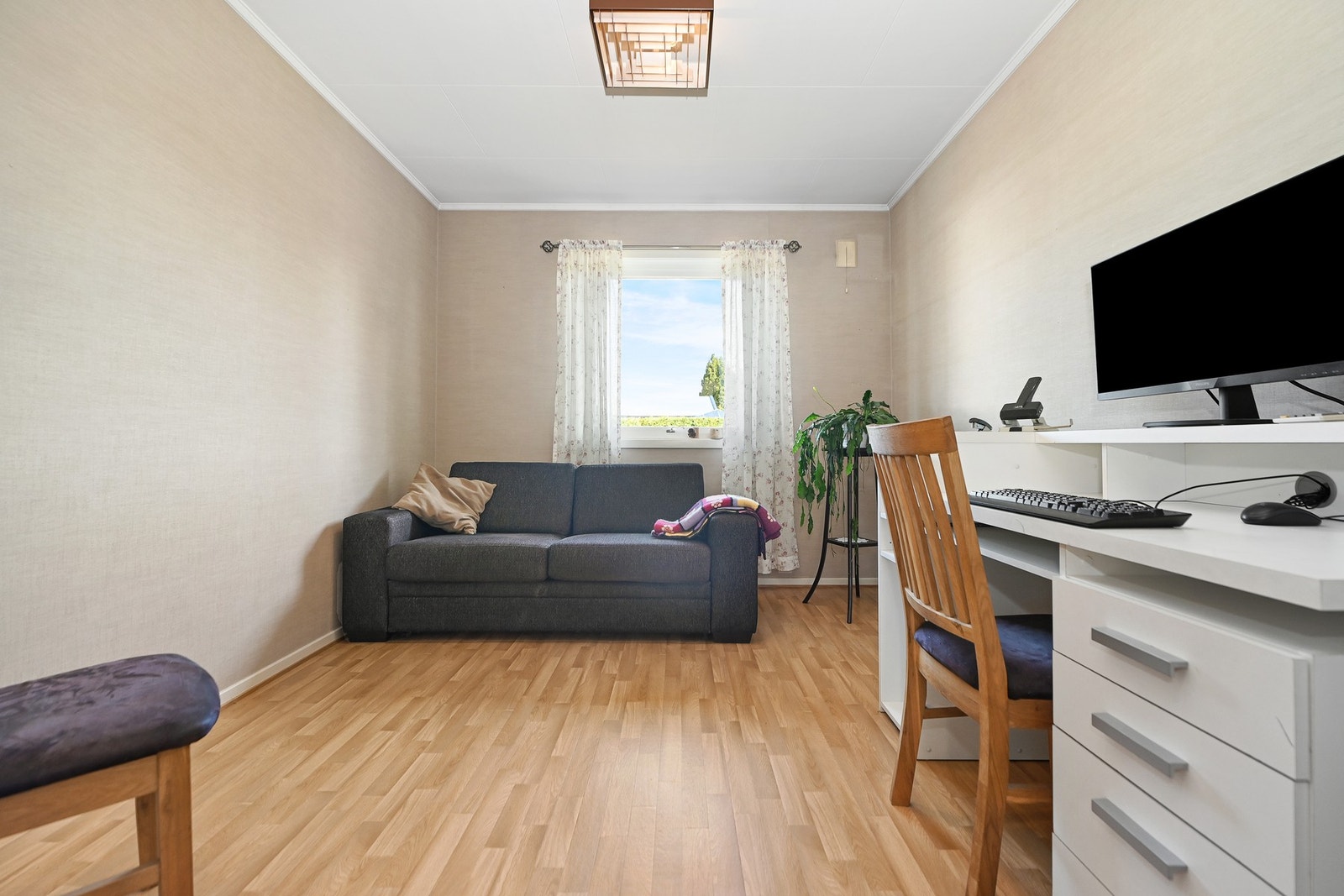 Rom med lyst laminatgulv, lyse vegger og stort vindu som gir godt lysinnslipp. Galleribilde