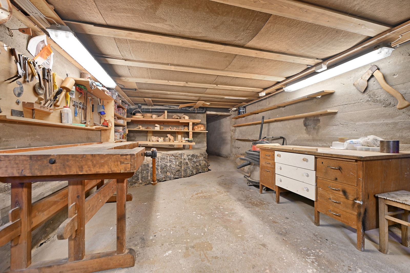 Romslig verksted med arbeidsbenk, hyller og verktøy. Galleribilde