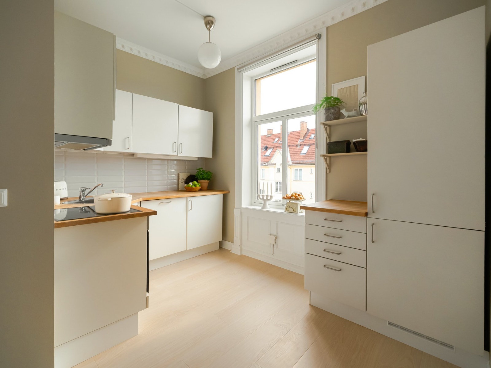 Det innholdsrike kjøkkenet er moderne med hvite fronter og benkeplate i heltre. Galleribilde