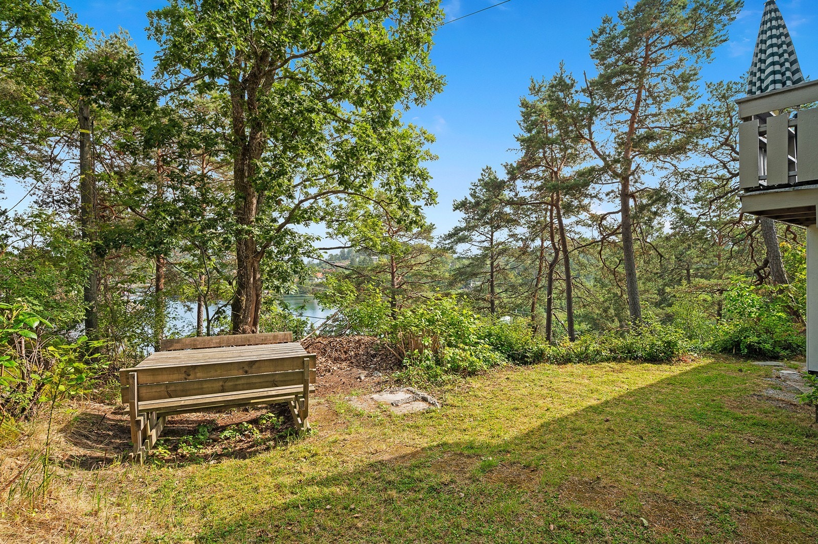 Hage består i all hovedsak av gressplen med plass til sittegruppe, lek og moro Galleribilde