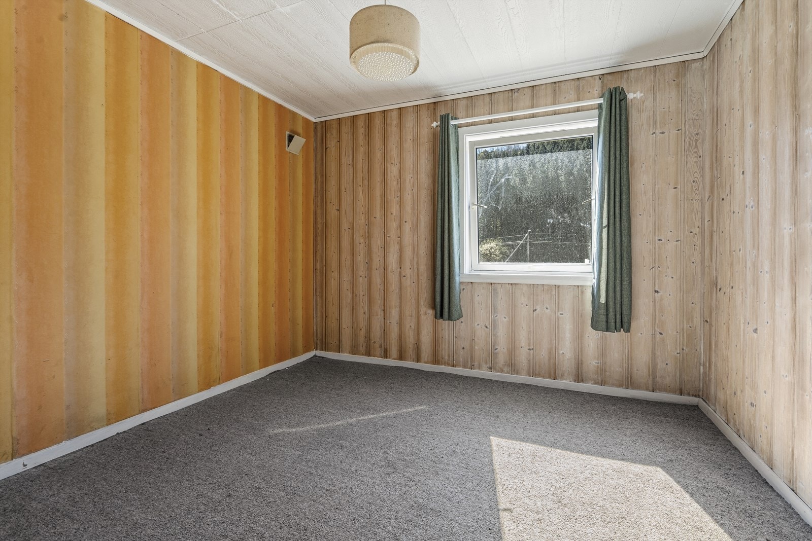 Dette rommet i kjelleretasjen har teppe på gulv og panel på vegger. Rommet er opprinnelig godkjent som bodareal. Galleribilde