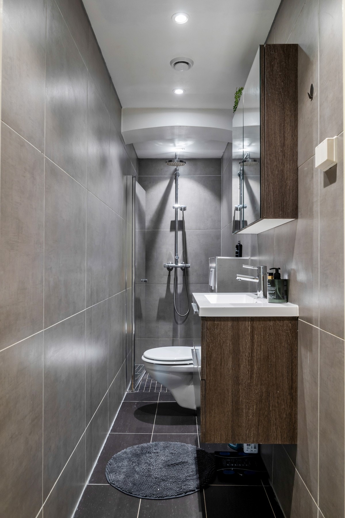 Badet i 1. etasje er oppført i 2016 og fremstår moderne med flislagte vegger og gulv. Badet er utstyrt med vegghengt toalett, servantinnredning med oppbevaring og dusjnisje med glassdør. Galleribilde