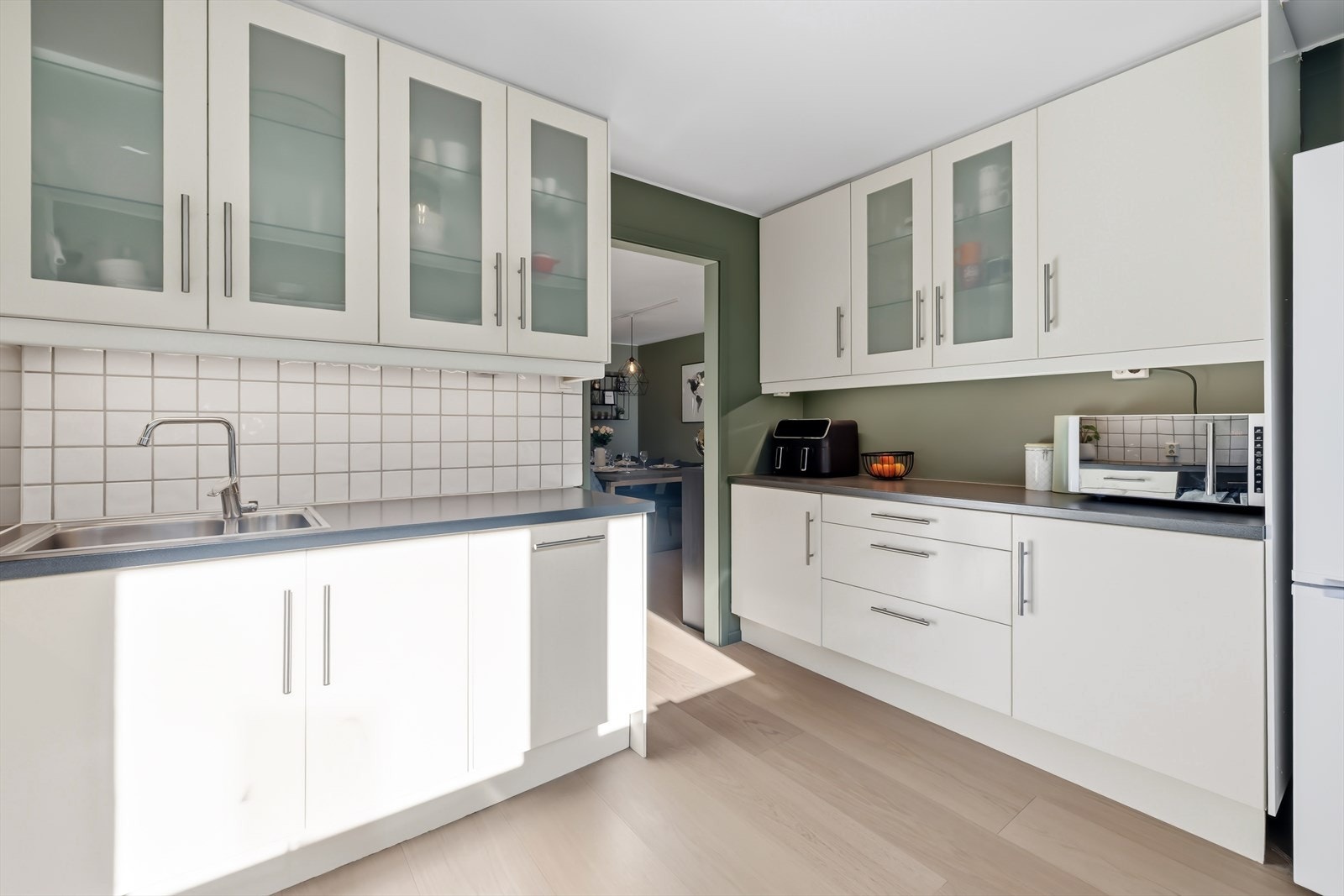 Kjøkkeninnredning med slette fronter, enkelte overskap har glassfronter Galleribilde