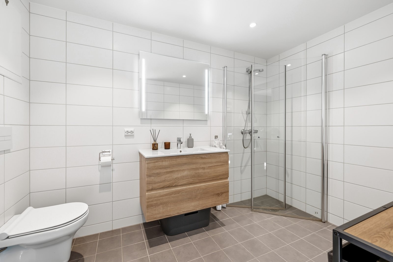 Badet er innredet med dusj, gulvmontert wc og baderomsinnredning Galleribilde