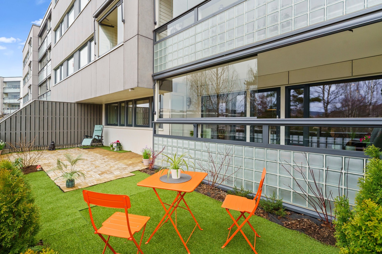 Fra balkongen er det videre adkomst til en hyggelig uteplass på bakkeplan med terrassegulv i treheller og et lite, skjermet hageparti - perfekt for avslappende stunder utendørs. Galleribilde